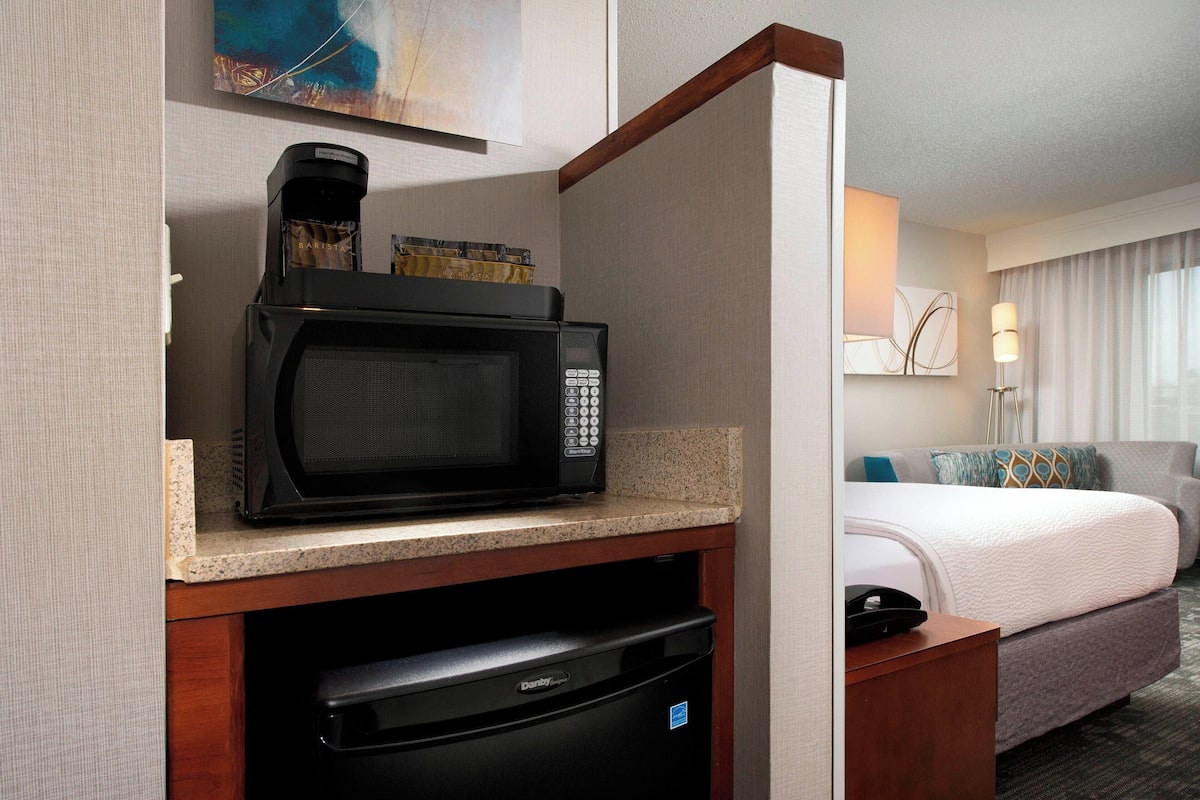 A compact kitchenette with a microwave, coffee maker, and dishwasher.