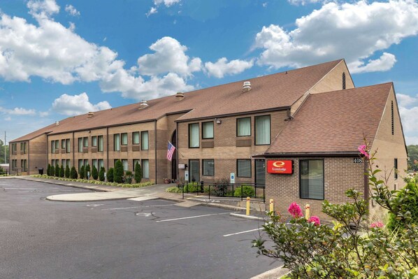 A modern hotel with a brick facade, multiple windows, and a parking lot. - Econo Lodge & Suites Southern Pines - Pinehurst (Southern Pines)