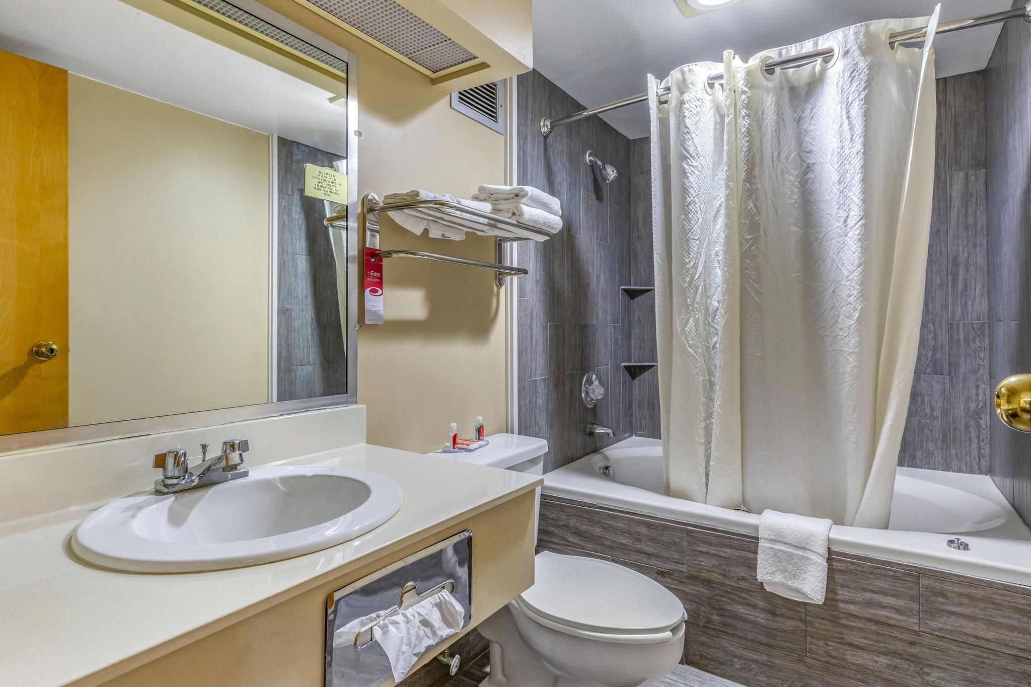 Un baño con lavamanos, inodoro y bañera.