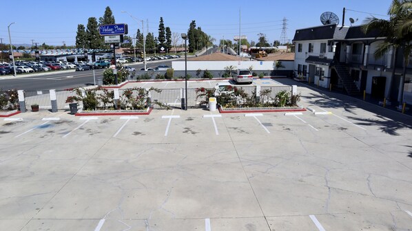 A parking lot with marked spaces, a Value Inn sign, and a building with a satellite dish.
