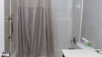 A bathroom with a bathtub, toilet, and vanity.