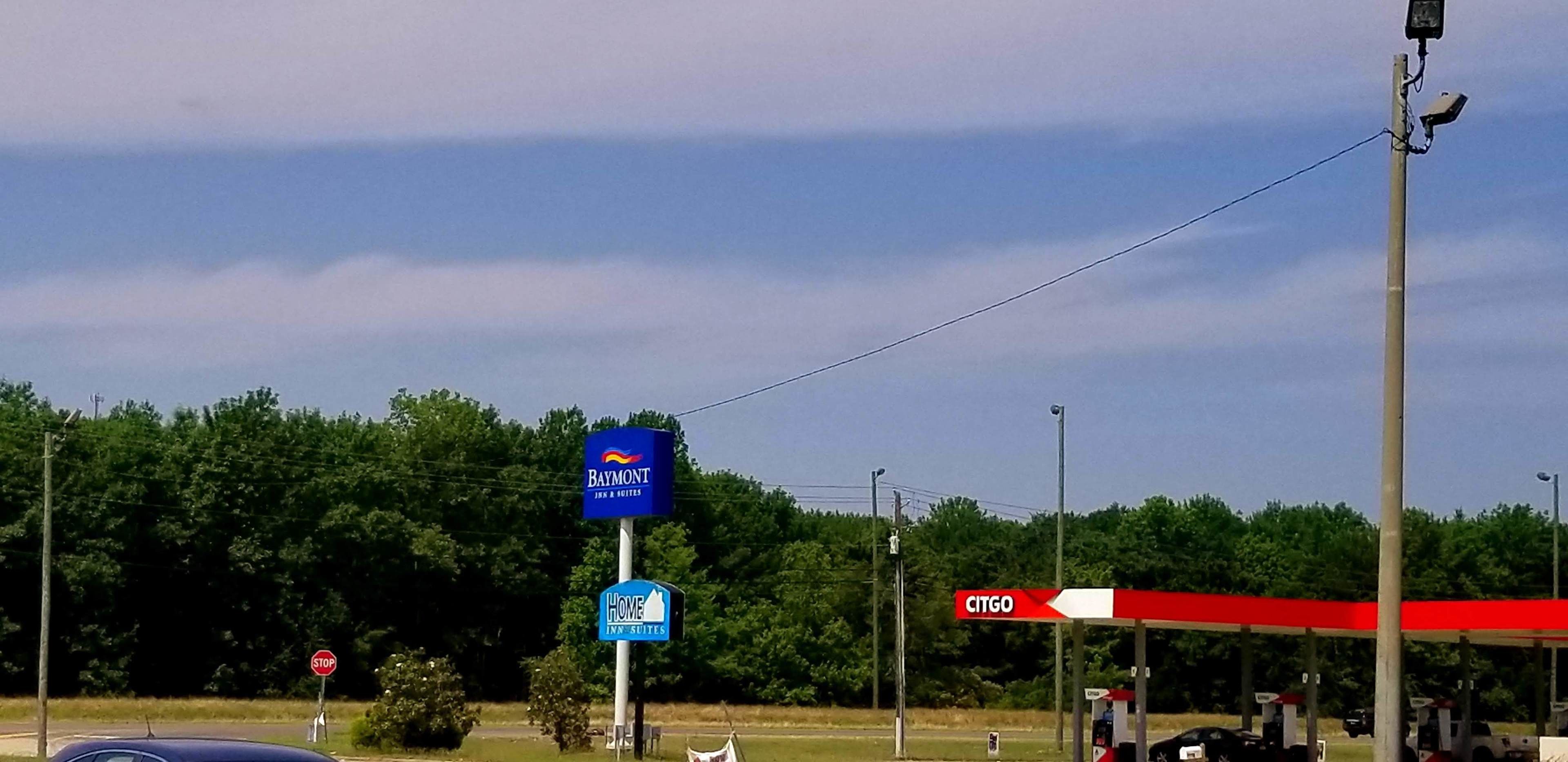 Un panneau indiquant un motel, un panneau de signalisation de stop et une station-service CITGO.