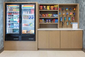 Een automaat en een display met snacks in een openbare ruimte.