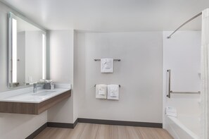 Un baño moderno con un espejo grande, dos lavamanos y una zona de ducha.