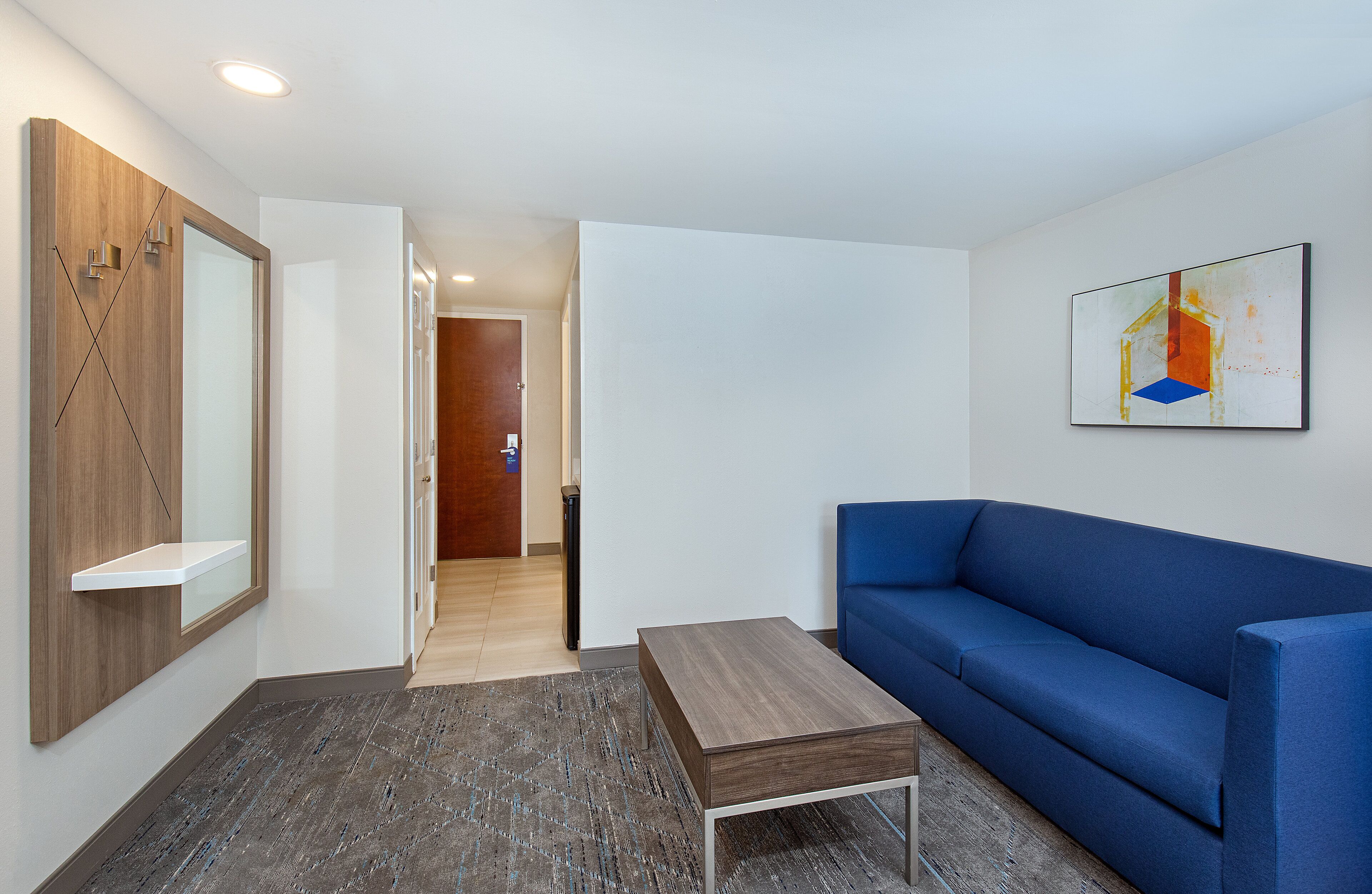 Una sala de estar moderna con un sofá azul, una mesa de centro de madera y un diseño minimalista.