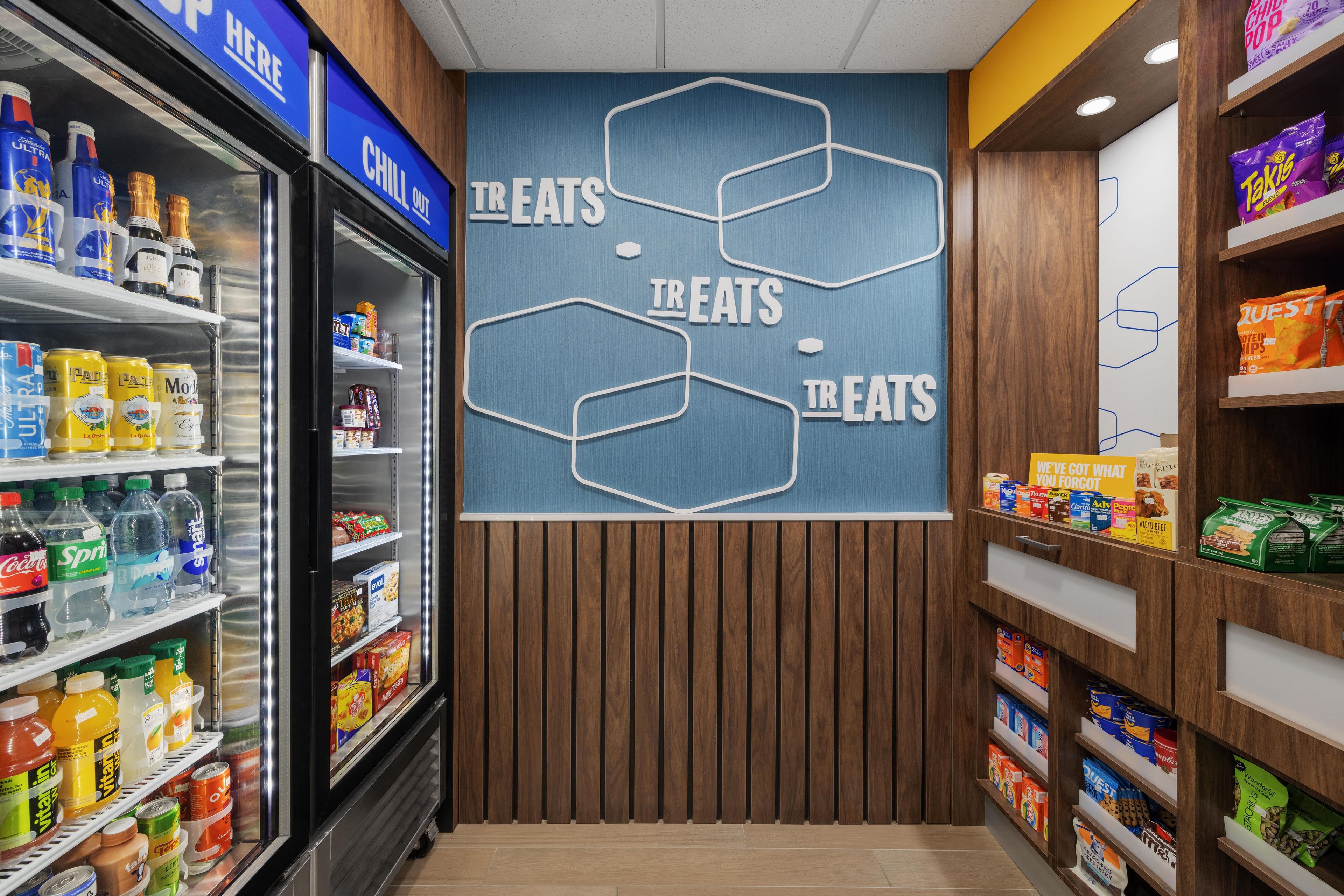 A grocery store interior with shelves stocked with snacks, beverages, and packaged goods.