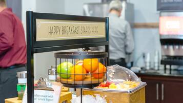 Een ontbijtstation met een bord waarop staat: HAPPY BREAKFAST STARTS HERE.