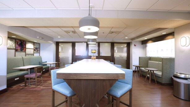 Un ristorante moderno con un'isola centrale, banquette e una zona bar.