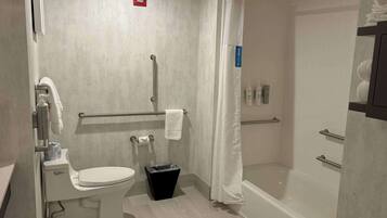 A modern bathroom with a toilet, shower, and a towel rack.