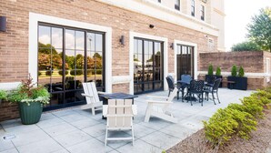 Un espace patio avec des sièges extérieurs et une façade en briques.