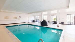 Une piscine intérieure à l’eau claire, dotée d’un poste de surveillance pour le sauveteur et d’un panneau indiquant qu’il est interdit de plonger.