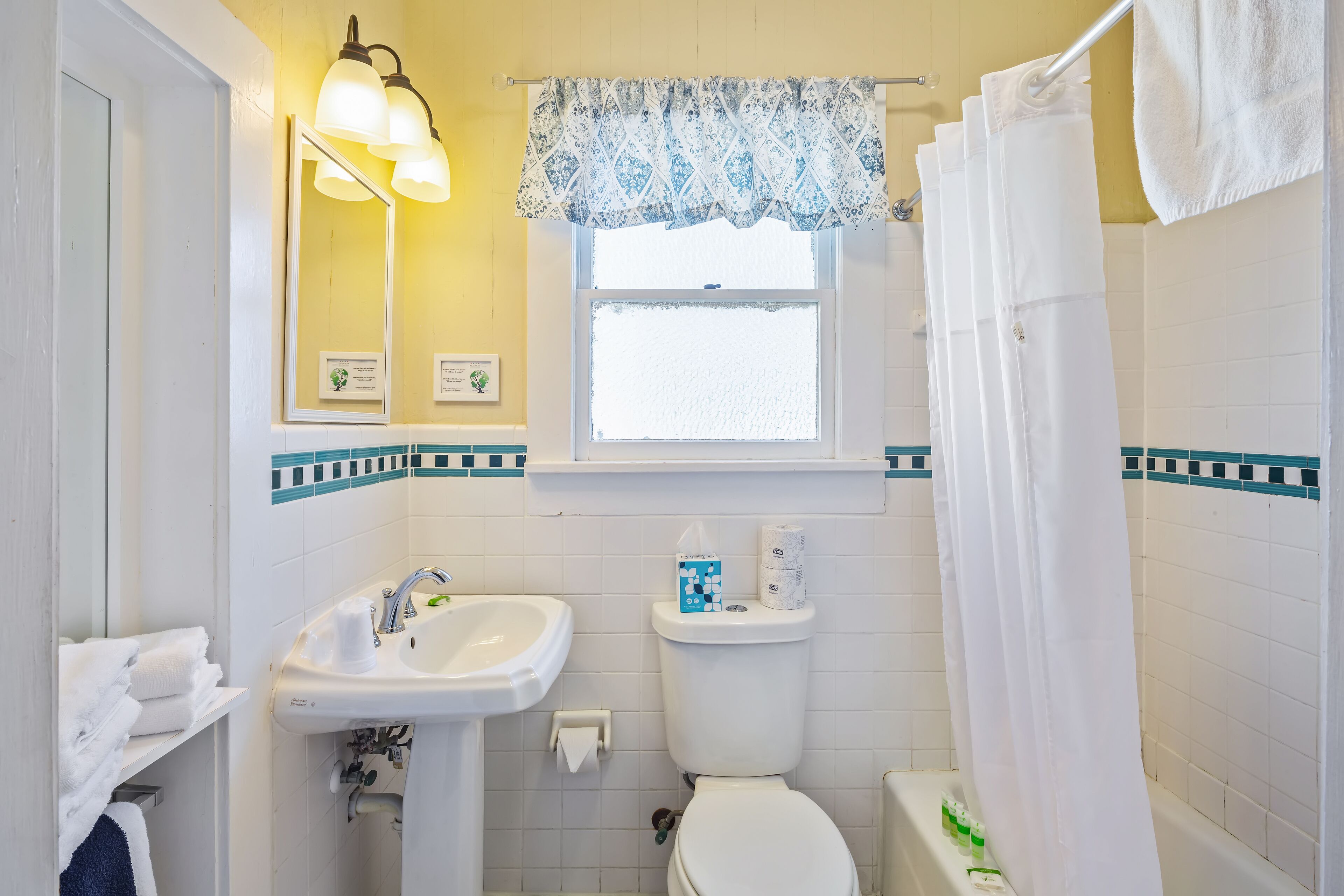 A bathroom with a sink, toilet, and shower curtain.