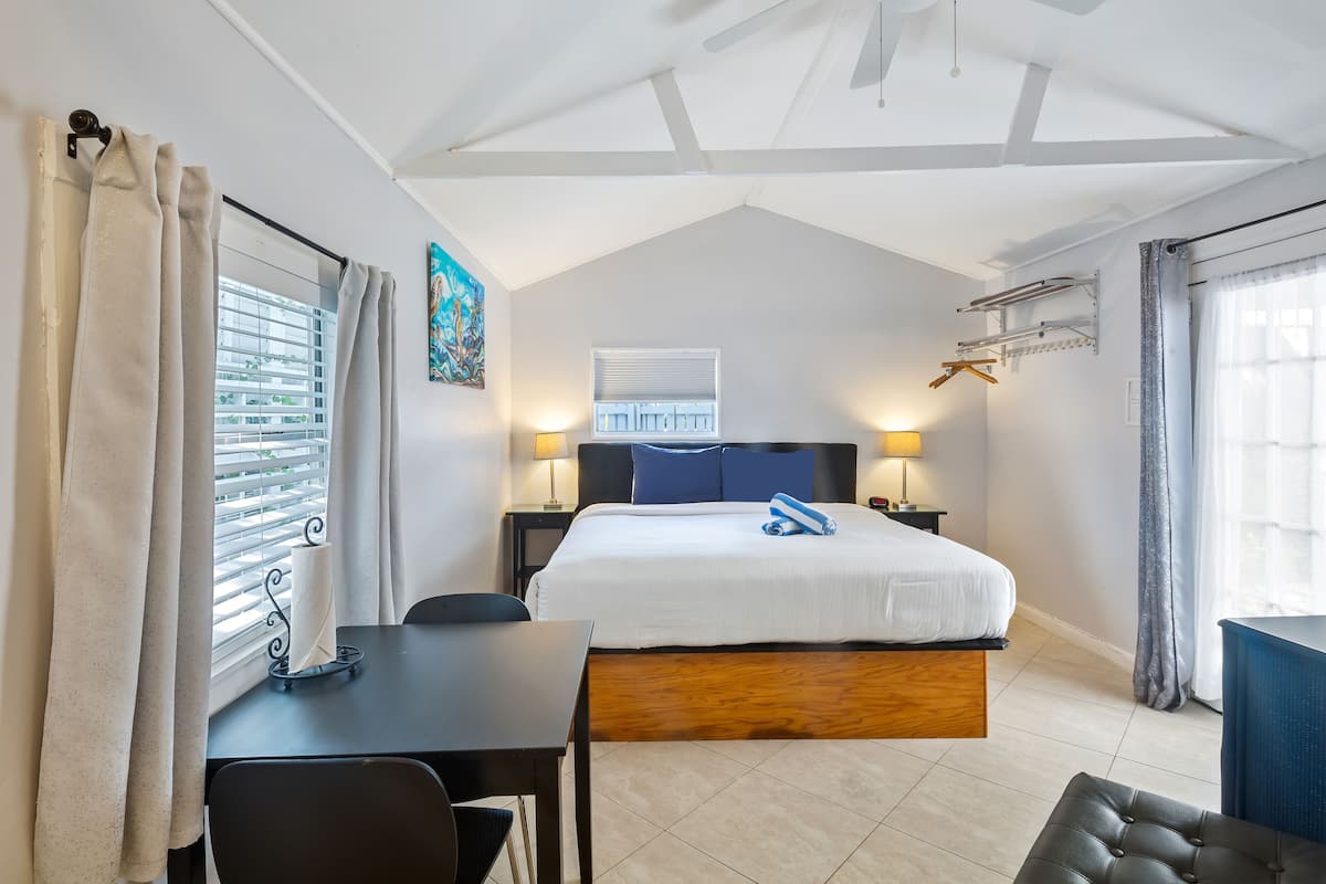 Une chambre à coucher avec un lit, des tables de chevet, un bureau et une chaise.