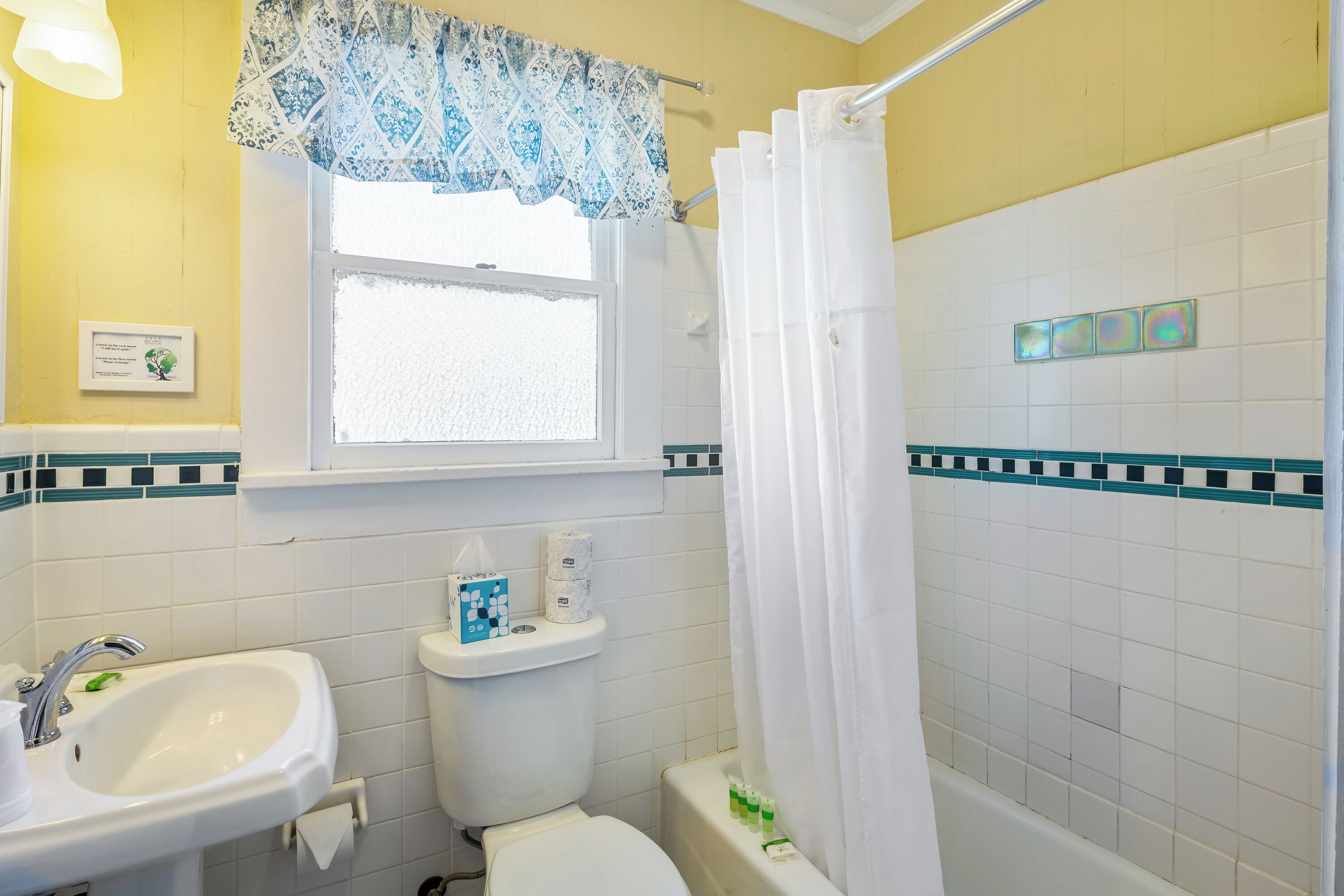 A bathroom with a sink, toilet, and shower curtain.