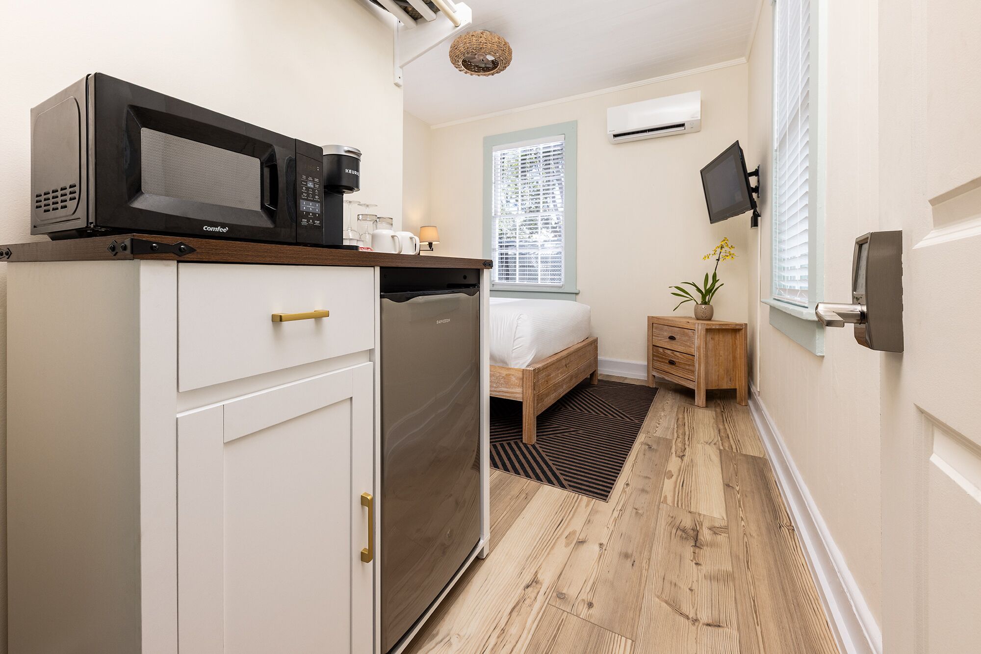 A compact kitchenette with a coffee maker, a microwave, and a refrigerator.