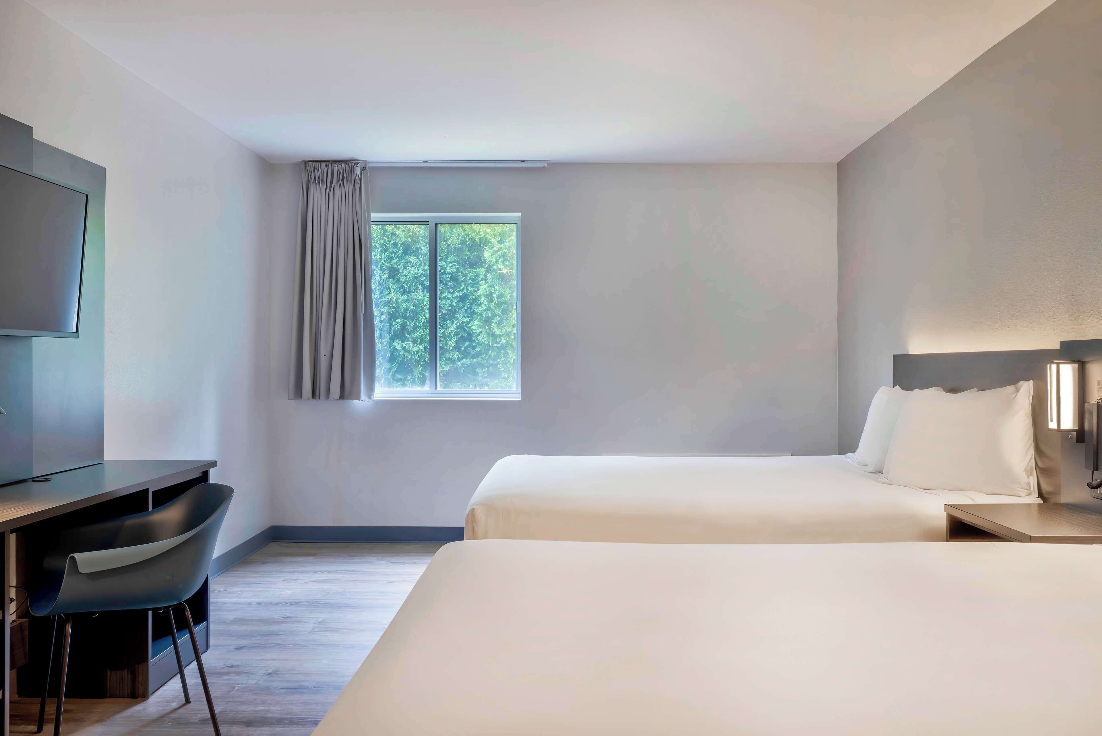 Une chambre d’hôtel avec un lit, un bureau et une télévision.