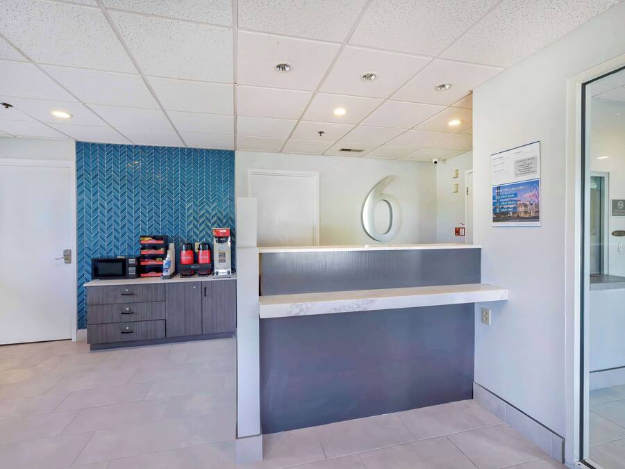 A modern reception area with a counter, a microwave, and a coffee station.
