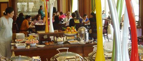 A buffet area with various food items and serving utensils.