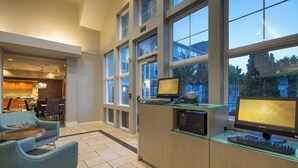 Una cocina moderna con ventanas amplias, un comedor con candelabro y una zona de estar con sofá azul y una mesa de centro.