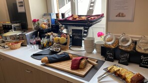 A breakfast buffet with various food items and utensils. - Hôtel Helvétique (Nice)
