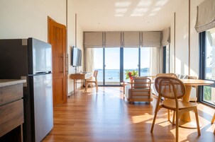 Una cocina moderna con refrigerador integrado, armarios de madera y un comedor con mesa y sillas.