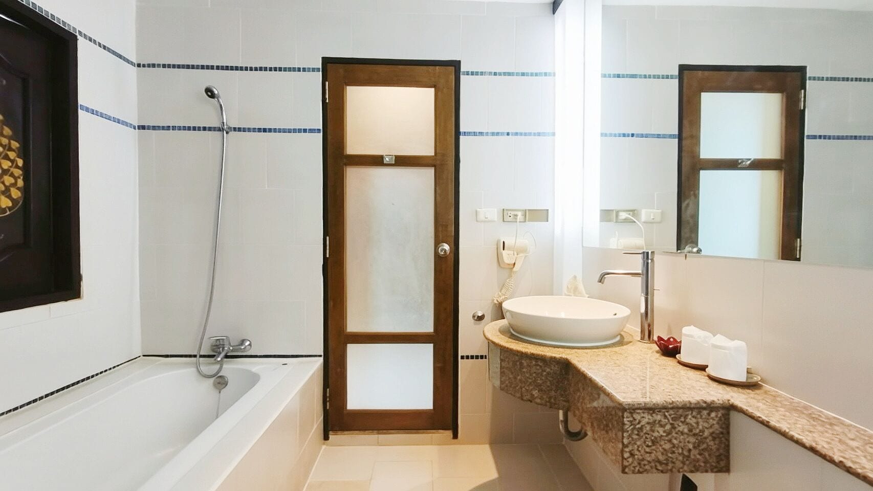 Une salle de bain avec une baignoire, un lavabo avec un miroir et un porte-serviettes.