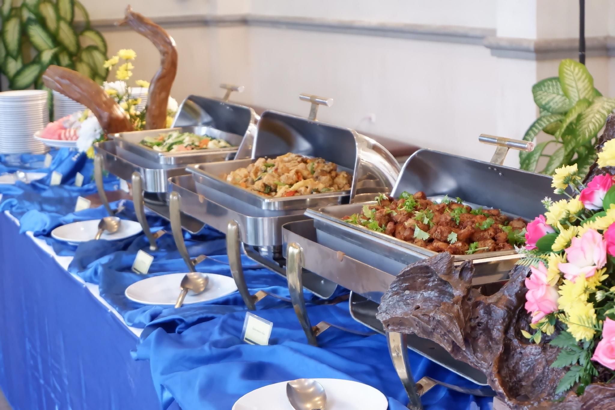 Una mesa de buffet con diversas opciones de comida y un centro de mesa decorativo.
