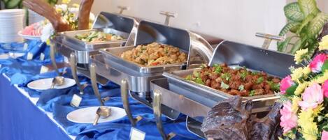 Una mesa de buffet con diversas opciones de comida y un centro de mesa decorativo.