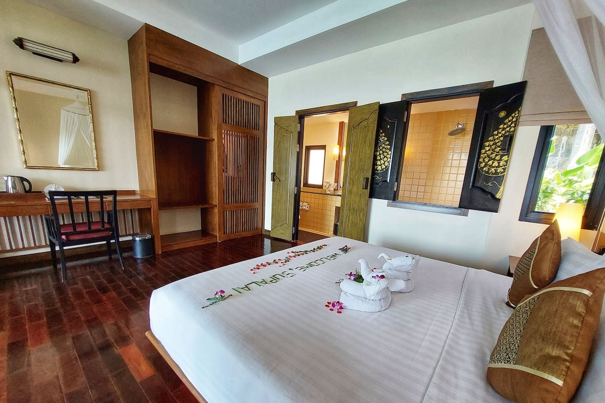 A hotel room with a bed, a desk, and a chair.