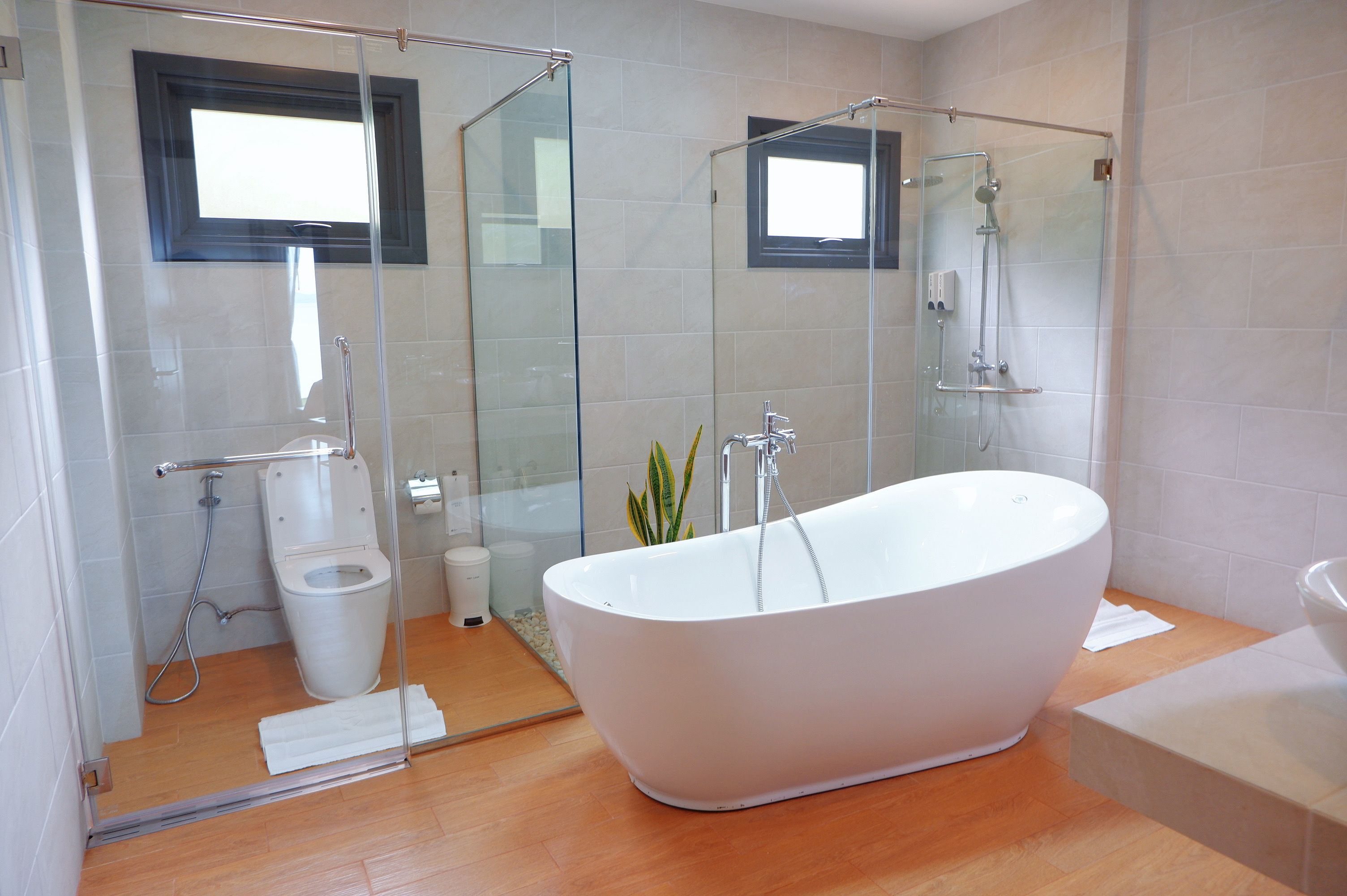 Une salle de bain moderne avec une baignoire sur pieds, une douche à parois de verre et des toilettes.