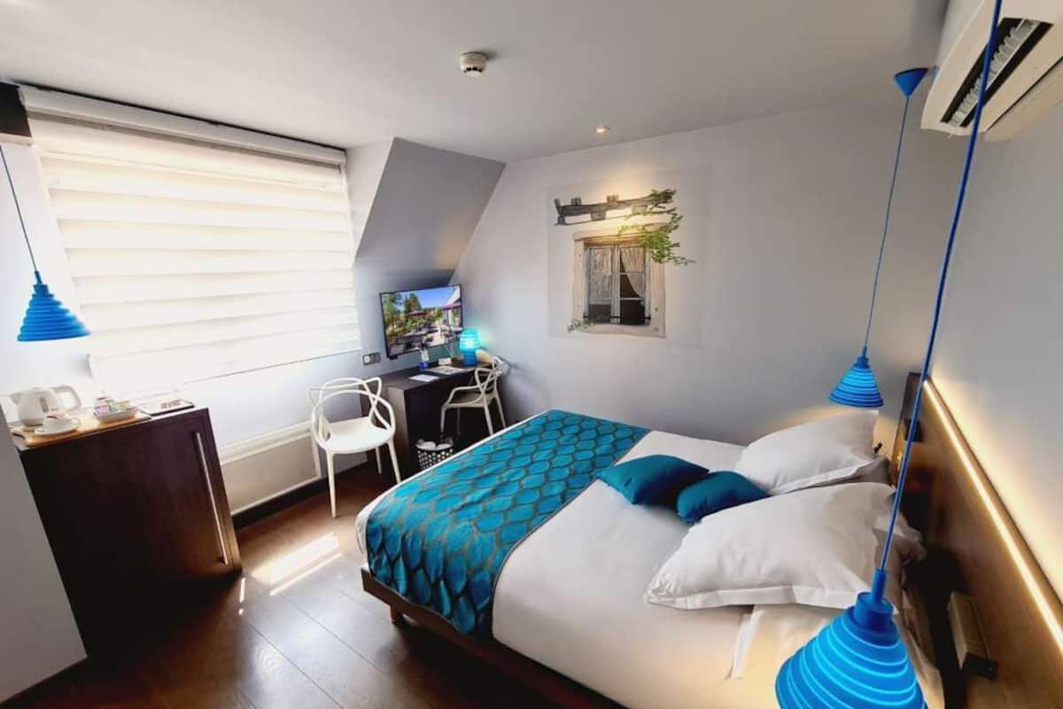 Ein modernes Hotelzimmer mit einem großen Bett, einem Schreibtisch und einem Sessel.