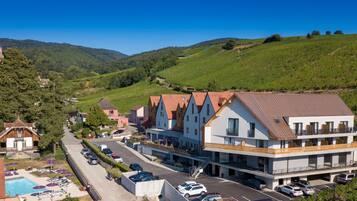 Un hôtel doté d’une piscine, de nombreux espaces de stationnement et offrant une vue sur les collines environnantes.