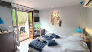 A modern hotel room with a large bed, a desk, and a view of the outdoors. - Best Western Plus Hotel & SPA Le Schoenenbourg (Riquewihr)