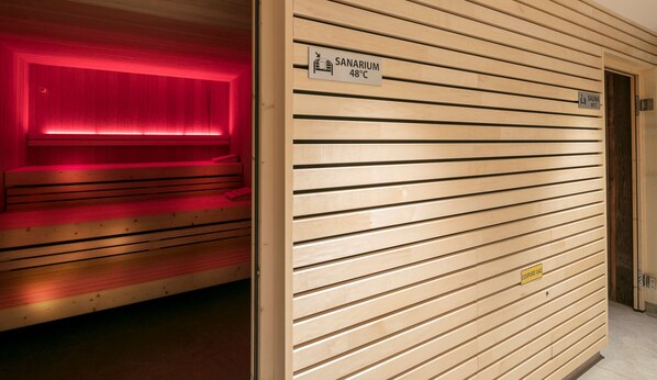 A sauna room with a red light, a wooden bench, and a sign indicating a temperature of 48°C. - Best Western Plus Hotel & SPA Le Schoenenbourg (Riquewihr)