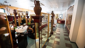 Interior de salón con espejos, un lavabo y suelo a cuadros.