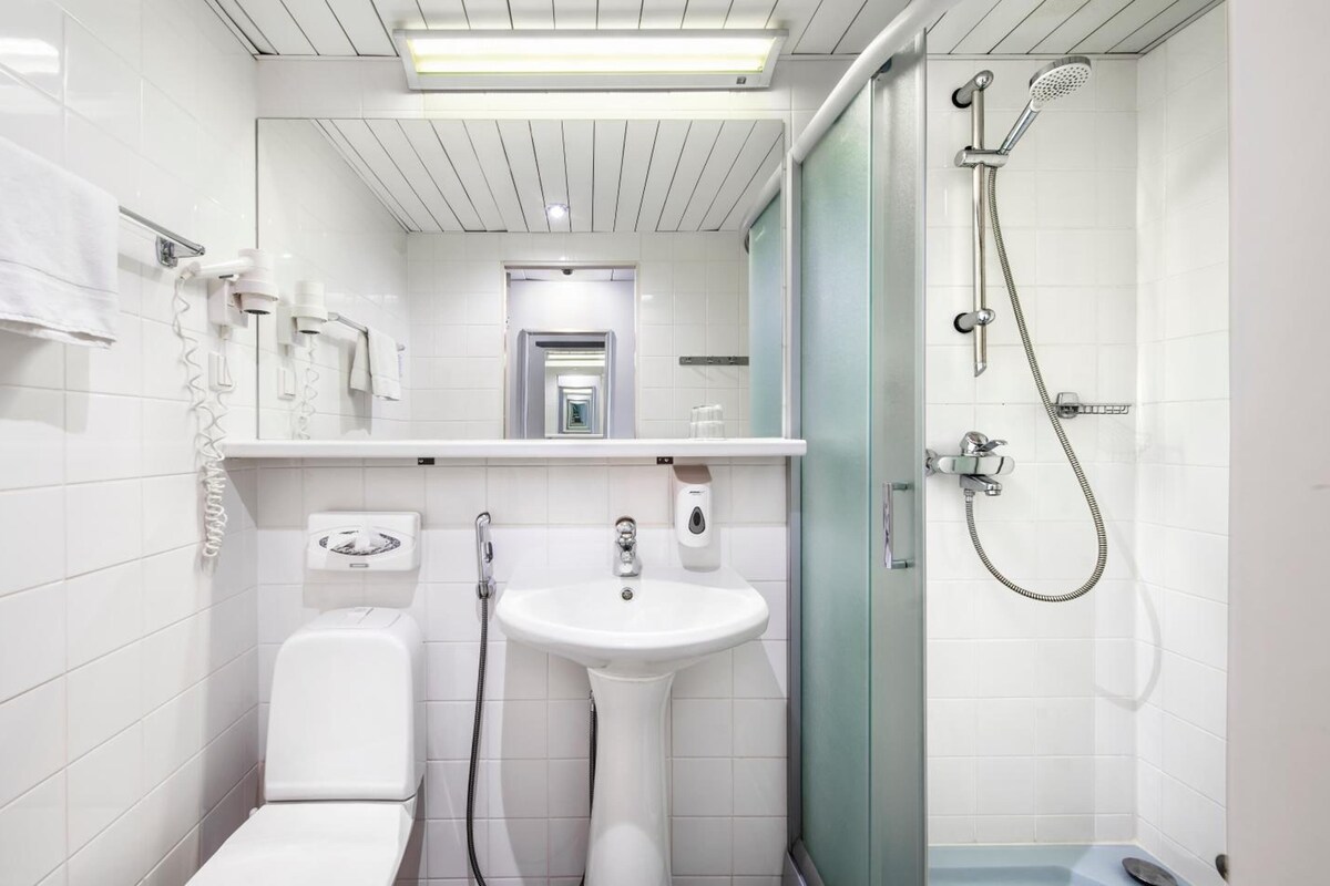 A modern bathroom with a toilet, sink, and shower.