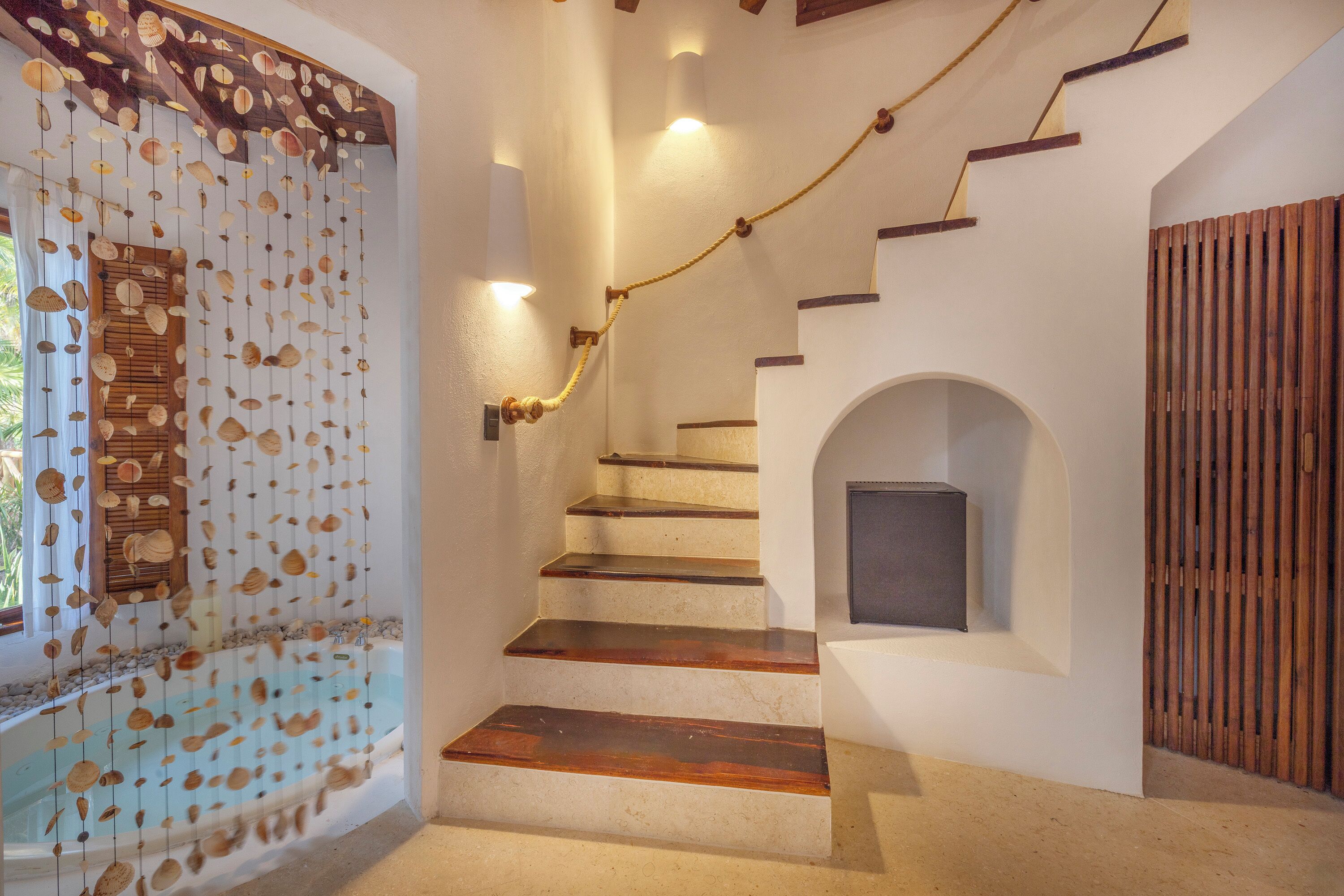 A staircase with wooden steps and a wall-mounted rope.