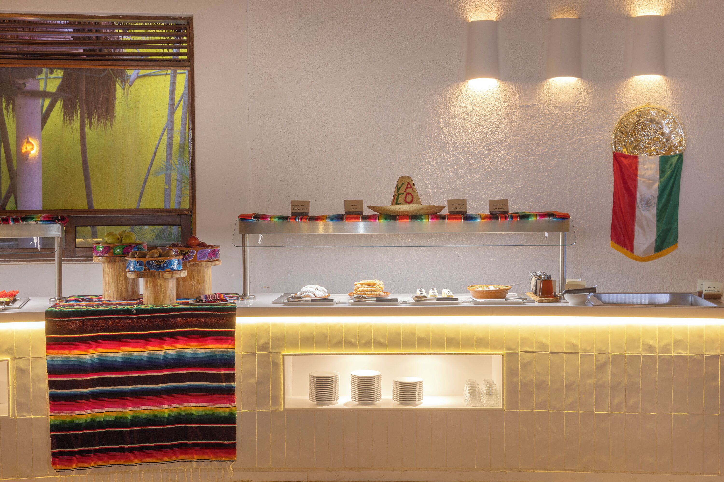 Ein Buffet mit einer bunten Tischdecke, einem Sombrero und einer mexikanischen Flagge.