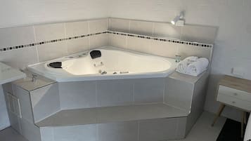 Ein modernes Badezimmer mit einer freistehenden Badewanne, einem Waschtisch mit Spiegel und einem Handtuchhalter.