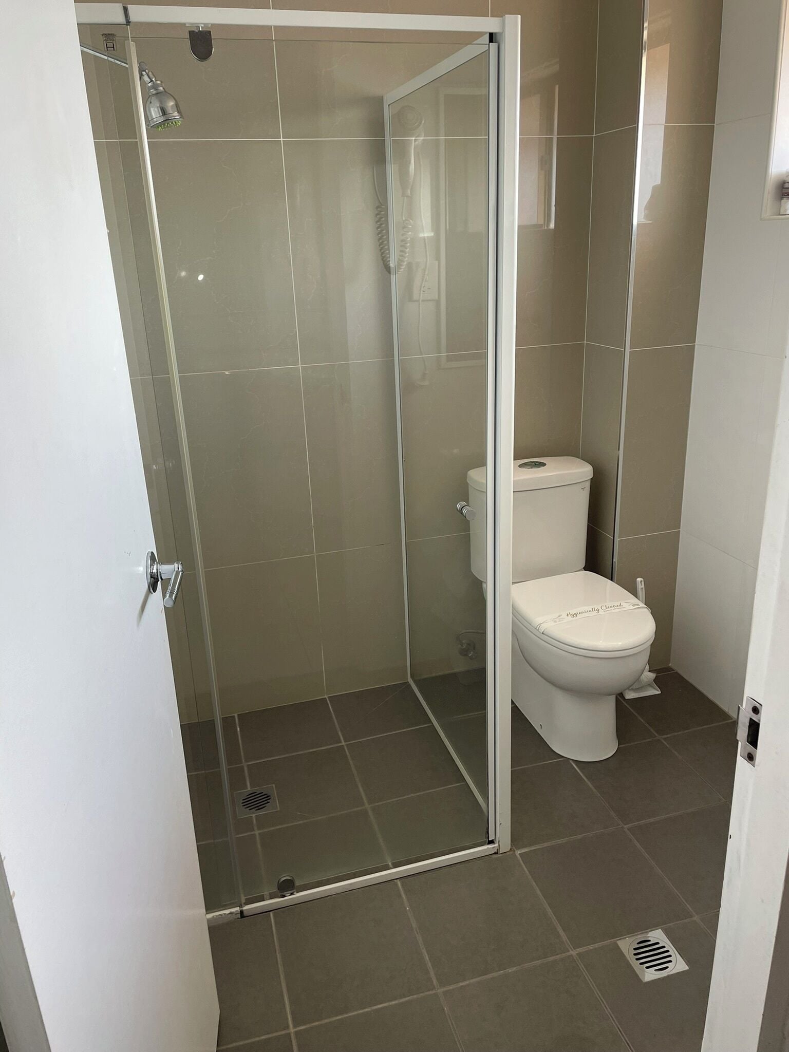 Une salle de bain avec une douche à parois de verre, des toilettes et un lavabo.