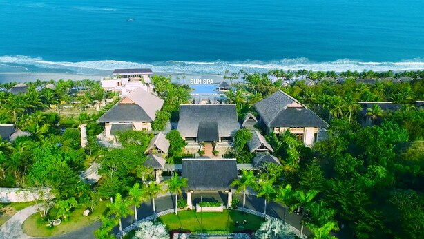 An aerial view of a resort with multiple buildings, a swimming pool, and a beach. - Sun Spa Resort & Villas (Dong Hoi)