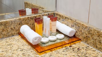 Una encimera de baño con artículos de aseo y toallas.