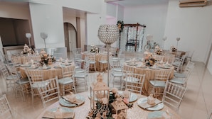 A round table with a glittery tablecloth, surrounded by white chairs with grey cushions. - Hotel Magic Mountain SPA & Conference center (La Fortuna)