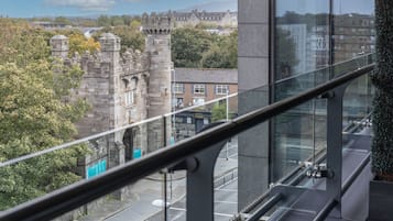 A view from a high-rise building overlooking a historic stone tower and modern buildings.