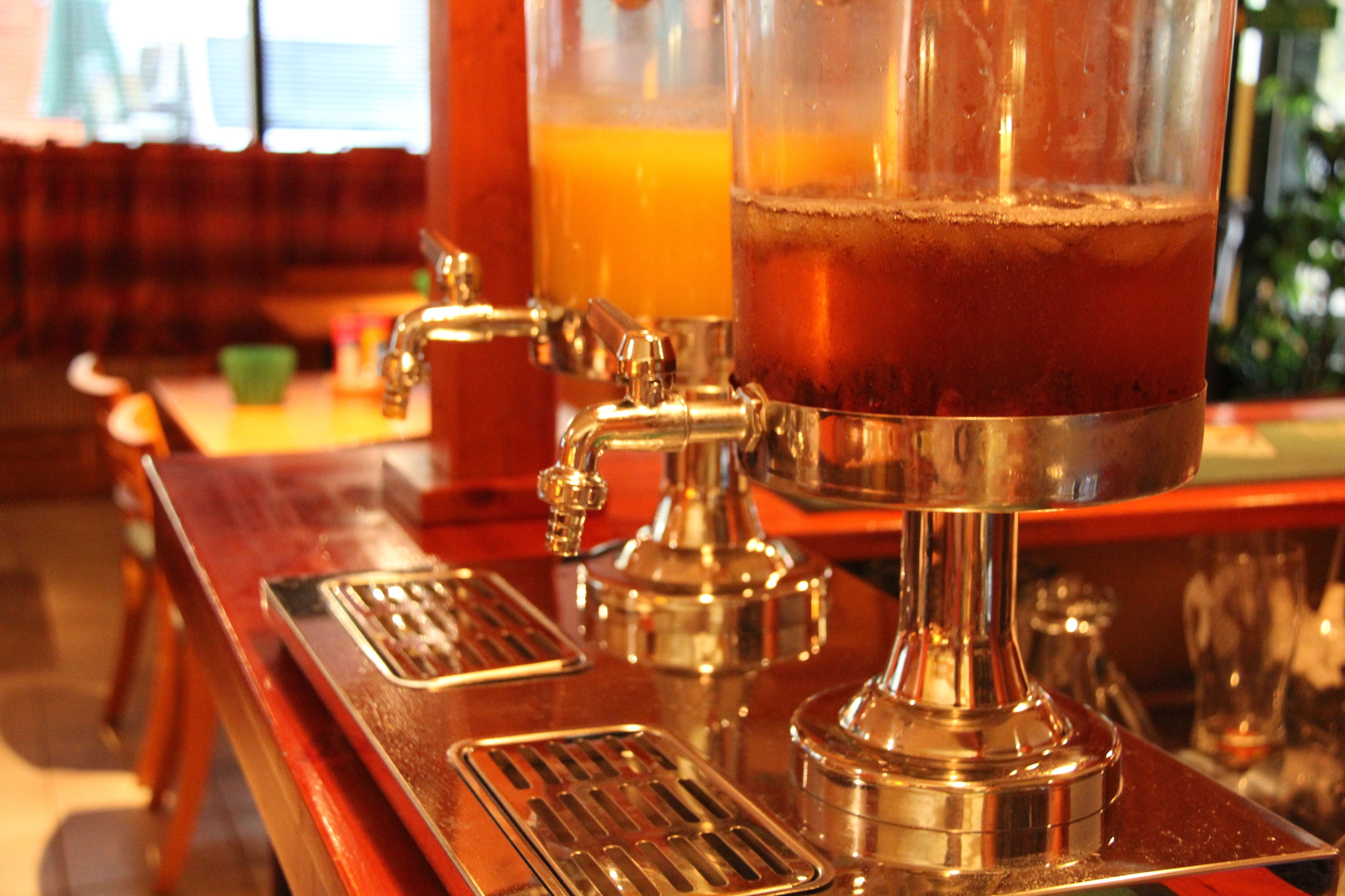 A bar area with a tap and a glass of amber-colored beverage.