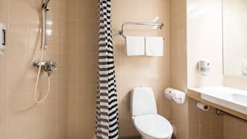 A bathroom with a shower, toilet, and sink.