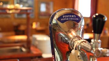 A bar tap labeled "Foster's Super Chilled" with a beer pump and a wooden bar counter in the background.