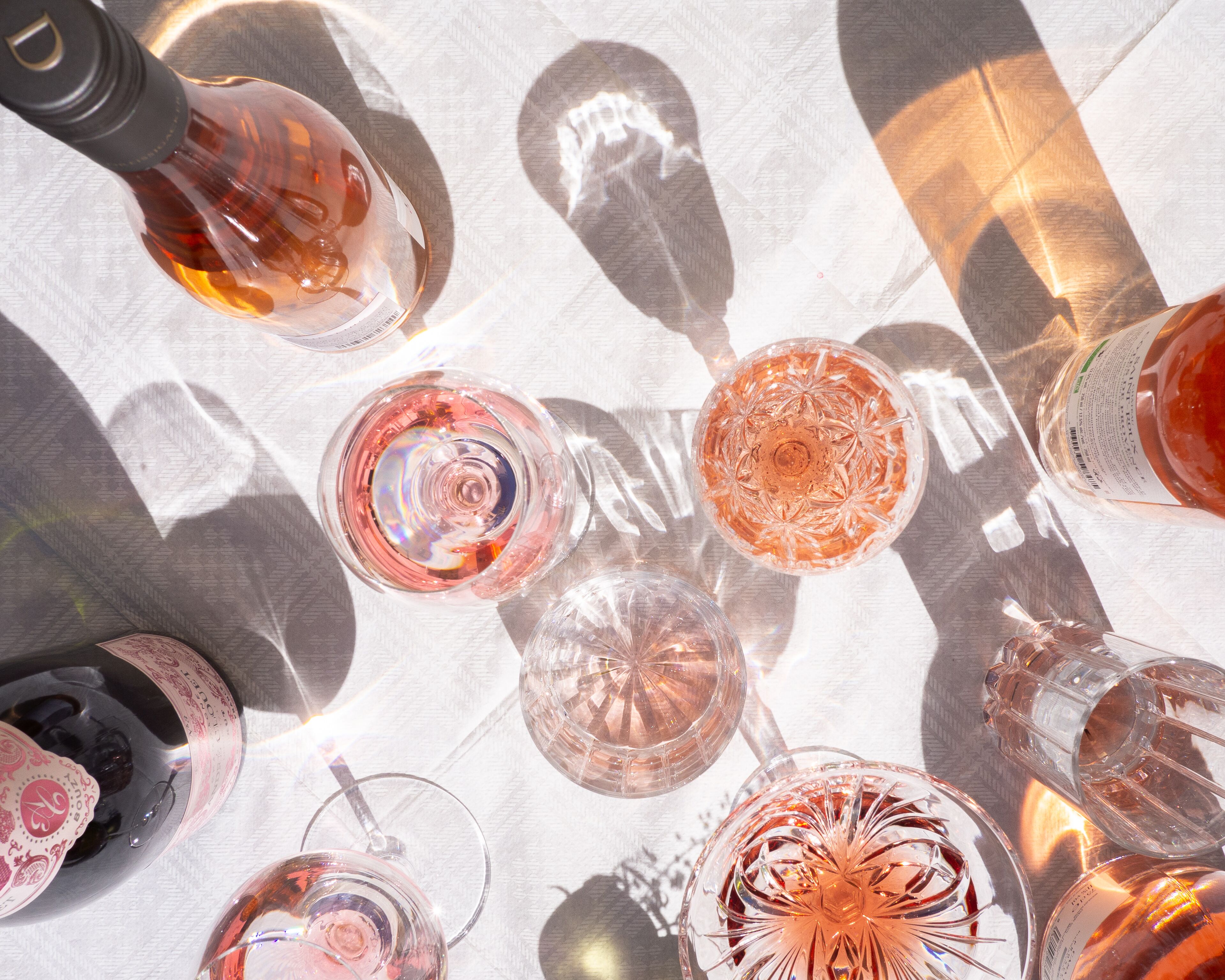 Une table avec différents types de verres et de bouteilles, probablement préparée pour une réception ou une réunion entre amis.