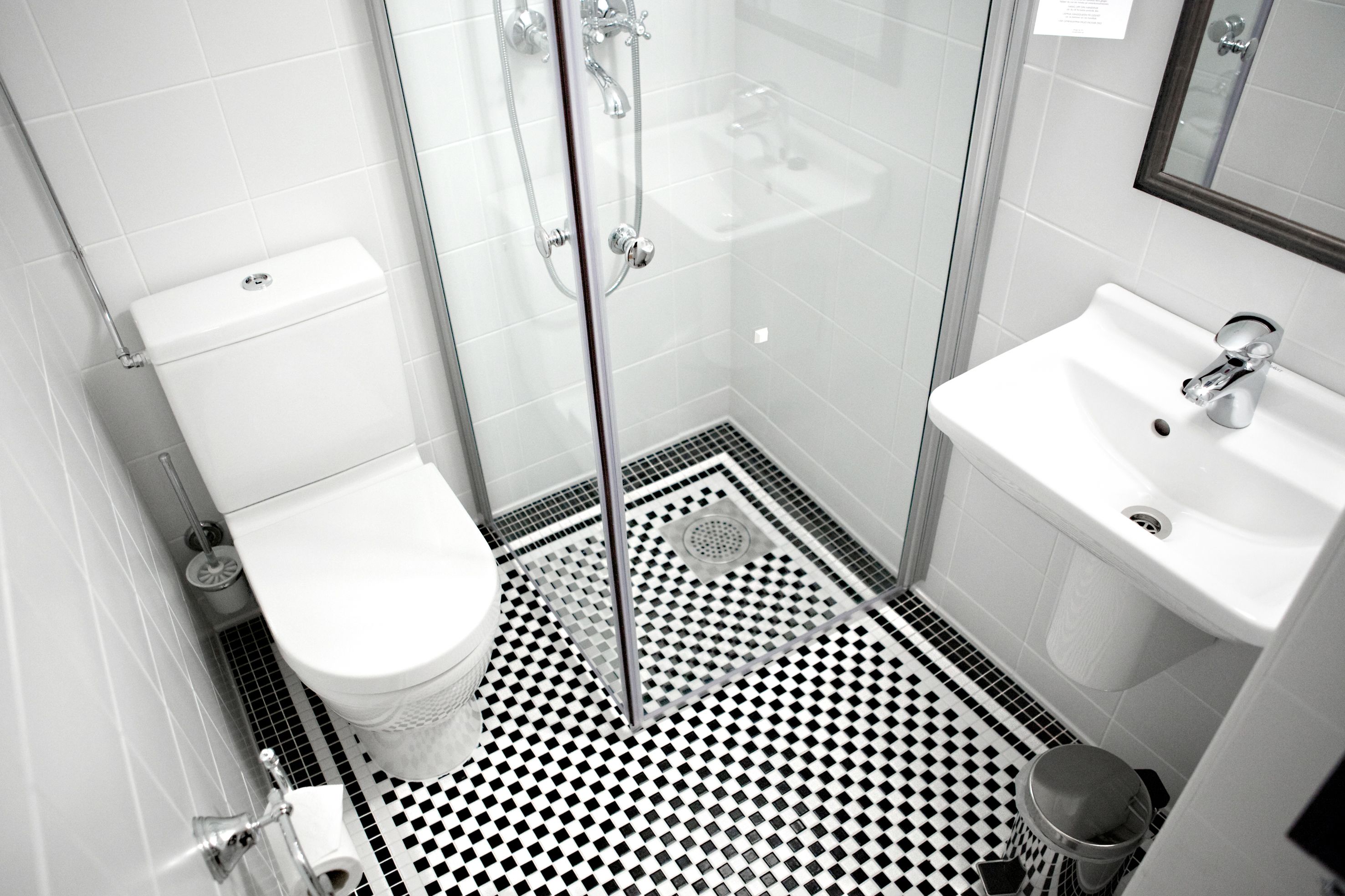 A bathroom with a toilet, shower, and sink.