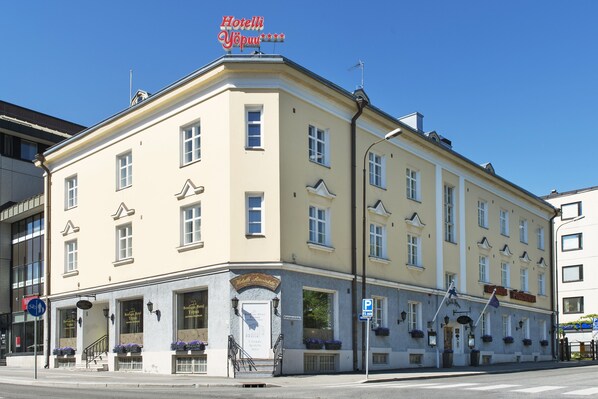 Ein Eckgebäude mit einem Schild, auf dem „Hotelli Yöpuu“ steht, und einem Schild für „Hotel Restaurant“.